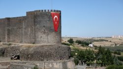 A Turkish flag hangs on the historical city walls at one of the entrance of Sur district in Diyarbakir