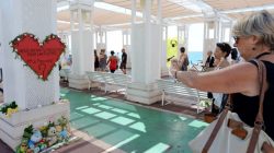 A woman takes a picture of a heart shape makeshift memorial before the minute of silence on the third day of national mourning to pay tribute to victims of the truck attack along the Promenade des Anglais on Bastille Day in Nice, France,