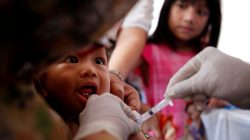 A child who received fake medication from a drug-making ring is revaccinated by government health care workers at a clinic in East Jakarta, Indonesia
