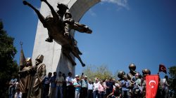 Supporters of Turkish President Tayyip Erdogan stand on the statue of Sultan Mehmed the Conqueror, during a pro-government demonstration in Sarachane park in Istanbul