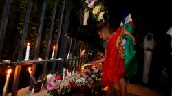 A Portuguese citizen places a candle during a candle vigil held at the French Embassy in Manama to condemn and mourn the attack in Nice, France, where a driver of a heavy truck ran into a crowd on Bastille Day killing at least 84 people