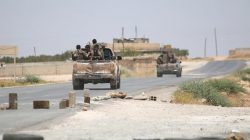 Syria Democratic Forces (SDF) ride vehicles along a road near Manbij, in Aleppo Governorate, Syria,