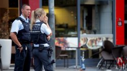 Police stand outside where a 21-year-old Syrian refugee killed a woman with a machete and injured two other people in the city of Reutlingen, Germany