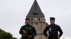 French police guard stand in front of church