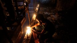A man lights a candle at the site after a suicide bombing in the Karrada shopping area, in Baghdad, Iraq July 3, 2016.