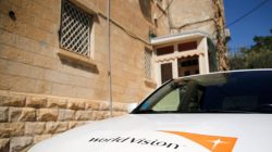 The logo of U.S.-based Christian charity World Vision is seen on a car parked outside their offices in Jerusalem