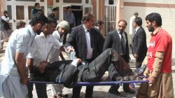 First responders and volunteers transport an injured man away from the scene of a bomb blast outside a hospital in Quetta