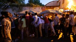 Migrants queue for food at a makeshift camp in Via Cupa (Gloomy Street) in downtown Rome, Italy,