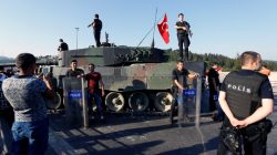 People pose with policemen after troops involved in the coup surrendered on the Bosphorus Bridge in Istanbul, Turkey