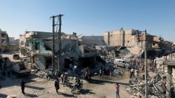 People inspect a site hit by airstrikes in the rebel held town of Atareb