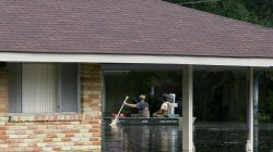 Residents use a boat to navigate through the floods in Louisiana