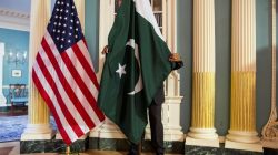 A State Department contractor adjust a Pakistan national flag before a meeting between U.S. Secretary of State John Kerry and Pakistan's Interior Minister Chaudhry Nisar Ali Khan on the sidelines of the White House Summit on Countering Violent Extremism at the State Department in Washington February 19, 2015.