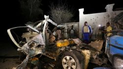 A Somali policeman looks at the wreckage of a vehicle destroyed by a car bomb at the Banadir beach restaurant at Lido beach in Somalia's capital Mogadishu,
