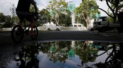 A man cycles past a construction site where locally transmitted Zika cases were first discovered in Singapore