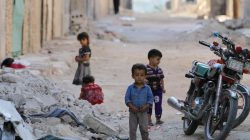 Children play along a street in the rebel-held al-Sheikh Said neighbourhood of Aleppo, Syria