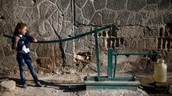 A girl fills a container with water on the first day of Eid al-Adha celebrations in the rebel held Douma neighbourhood of Damascus, Syria September