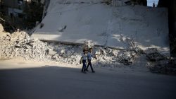 Boys walk near a damaged building on the first day of Eid al-Adha celebrations in the rebel held Douma neighbourhood of Damascus