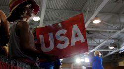 Eight year-old Emma Gray Bachrodt holds a "USA" sign while U.S. Democratic presidential candidate Hillary Clinton speaks at a campaign voter registration event at Johnson C. Smith University in Charlotte