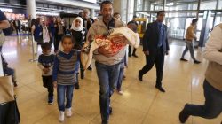 Syrian refugee Ahmad al Aboud, and his family members, who will be resettled in the United States, walk to board their plane in Amman, Jordan,