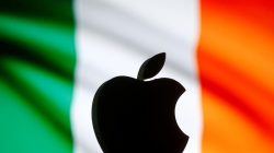 A 3D printed Apple logo is seen in front of a displayed Irish flag in this illustration