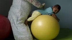Physiotherapist Leal does exercises with Lucas, 4-months old, who is Miriam Araujo's second child and born with microcephaly in Pedro I hospital in Campina