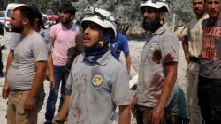 Civil Defence members with blood on their shirts stand after double airstrikes on the rebel held Bab al-Nairab neighborhood of Aleppo.