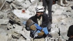 A civil defence member carries a dead child in a site hit by what activists said were airstrikes carried out by the Russian air force in the rebel-controlled area of Maaret al-Numan town in Idlib province, Syria