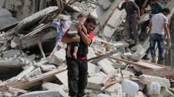 A man carries an injured child after airstrikes on the rebel held al-Qaterji neighbourhood of Aleppo, Syria September 21, 2016.
