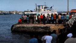 People gather along the shore of the Mediterranean Sea during a search for victims after a migrant boat capsized, in Al-Beheira, Egypt