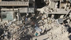 People dig in the rubble in an ongoing search for survivors at a site hit previously by an airstrike in the rebel-held Tariq al-Bab neighborhood of Aleppo,