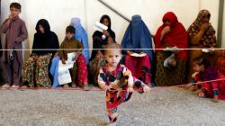 Afghan women sit with their children after arriving at a United Nations High Commissioner for Refugees