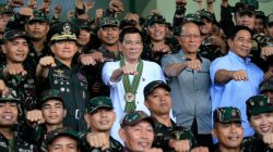 Philippines President Rodrigo Duterte clenches fist with members of the Philippine Army during his visit at the army