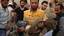A medic holds a dead child after airstrikes in the rebel held Karam Houmid neighbourhood in Aleppo