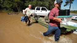 Men carry belongings from a neighbours home as flood waters rise after Hurricane Matthew in Lumberton, North Carolina,