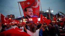 A supporter holds a flag depicting Turkish President Tayyip Erdogan during a pro-government demonstration in Ankara, Turkey,