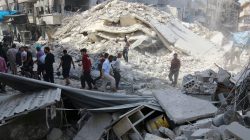 People inspect the damage at a market hit by airstrikes in Aleppo's rebel held al-Fardous district, Syria