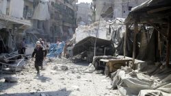 A civil defence member runs at a market hit by air strikes in Aleppo's rebel-held al-Fardous district, Syria