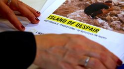 Anna Neistat, Senior Director for Research with Amnesty International, talks to journalists as she holds a copy of a report she co-authored titled 'Island of Despair - Australia's "Processing" of Refugees on Nauru' in Sydney, Australia