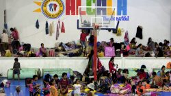 Evacuees from the coastal villages take shelter inside an evacuation center as Typhoon Haima locally name Lawin approaches, in Alcala town, Cagayan province, north of Manila