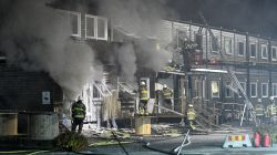 Firefighters extinguish a fire that broke out at a refugee accommodation in Fagersjo, south of Stockholm, Sweden on the night of October 16,