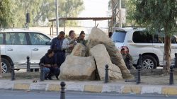 Peshmerga forces stand behind rocks at a site of an attack by Islamic State militants in Kirkuk, Iraq,