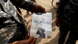 An Iraqi soldier shows a pamphlet which reads "Wearing beards is compulsory, shaving is prohibited" along a street of the town of al-Shura, which was recaptured from Islamic State (IS) on Saturday, south of Mosul