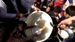Recently displaced people rush a food distribution point in Khazer refugee camp,