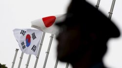 Officer near Japan and South Korea flags