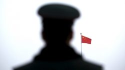 A paramilitary policeman watches a flag-raising ceremony at Tiananmen Square ahead of the opening session of the National People's Congress (NPC) in Beijing, China,