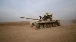 Shi'ite fighters ride on a tank heading toward the airport of Tal Afar during a battle with Islamic State militants in Tal Afar west of Mosul, Iraq