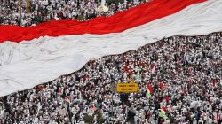 Members of hardline Muslim groups hold a big national flag as they attend a protest against Jakarta's incumbent governor Basuki Tjahaja Purnama, an ethnic Chinese Christian running in the upcoming election, in Jakarta, Indonesia