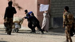 A woman waves a white flag in Mosul, Iraq