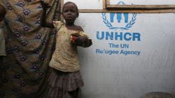 girl eats meal in front of New Prison camp in Nigeria
