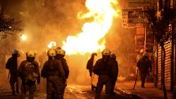 A petrol bomb explodes next to riot police during clashes following an anniversary rally marking the 2008 police shooting of 15-year-old student, Alexandros Grigoropoulos, in Athens, Greece,